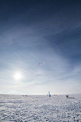 Image showing Kiteboarder with blue kite on the snow