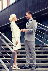 Image showing smiling businessmen shaking hands on street