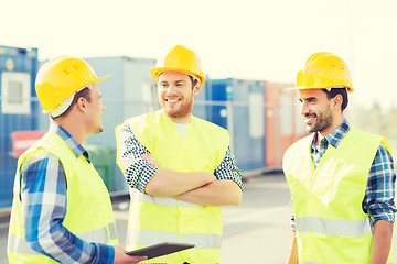 Image showing smiling builders in hardhats with tablet pc