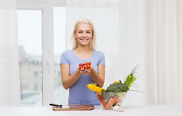 Image showing smiling young woman cooking vegetables at home