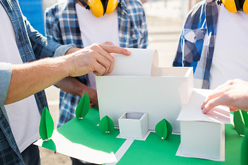 Image showing close up of builders with paper house model