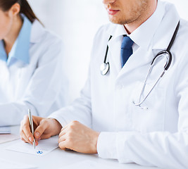 Image showing doctor and nurse writing prescription paper