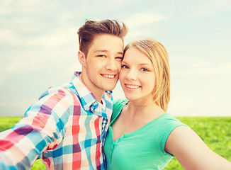 Image showing smiling couple with smartphone in suburbs