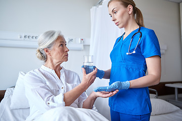 Image showing nurse giving medicine to senior woman at hospital