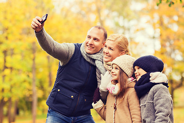 Image showing happy family with camera in autumn park