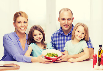 Image showing happy family with two kids with salad at home