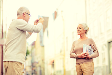 Image showing senior couple photographing on city street