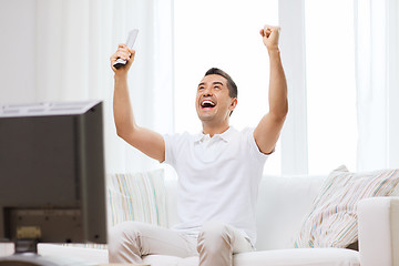 Image showing smiling man watching sports at home