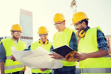 Image showing group of builders with tablet pc and blueprint