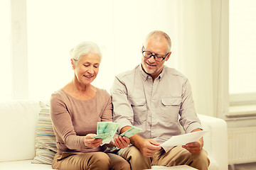 Image showing senior couple with money and calculator at home