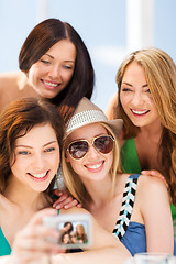 Image showing girls taking photo in cafe on the beach