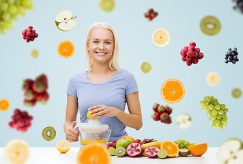 Image showing smiling woman squeezing fruit juice