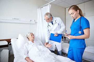 Image showing doctor and nurse visiting senior woman at hospital