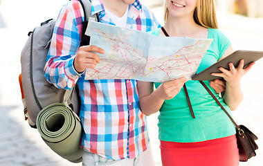 Image showing smiling couple with map and backpack in city