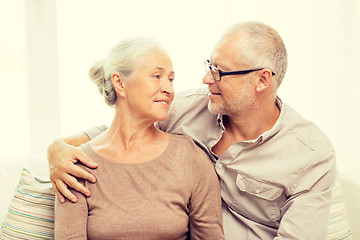 Image showing happy senior couple hugging on sofa at home