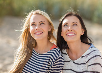 Image showing happy teenage girls or young women on beach
