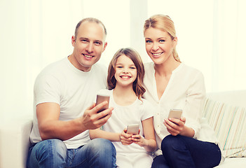 Image showing parents and little girl with smartphones at home