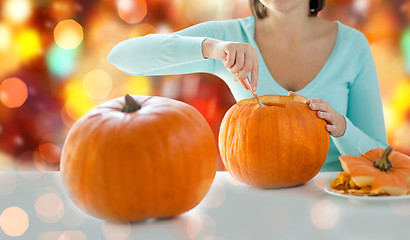 Image showing close up of woman carving pumpkins for halloween