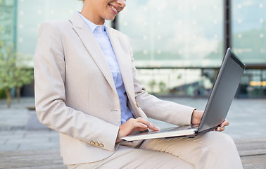 Image showing close up of business woman with laptop in city