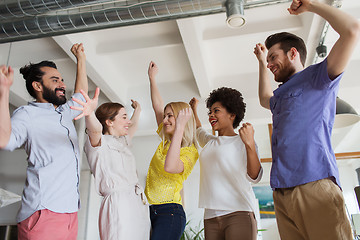 Image showing happy creative team celebrating victory in office