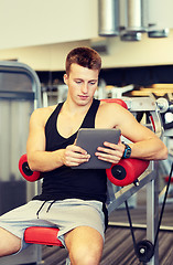 Image showing young man with tablet pc computer in gym