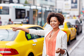 Image showing happy african woman catching taxi