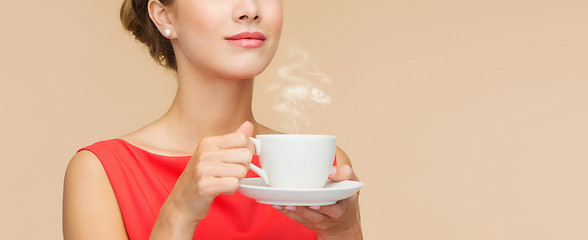 Image showing smiling woman in red dress with cup of coffee