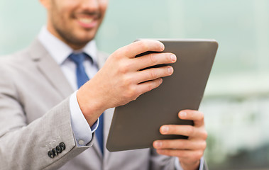 Image showing close up of business man with tablet pc in city