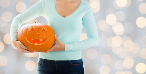 Image showing close up of woman with carved halloween pumpkin