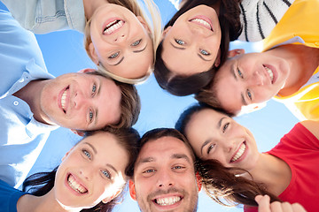 Image showing smiling friends in circle on summer beach