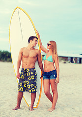 Image showing smiling couple in sunglasses with surfs on beach