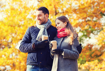 Image showing smiling couple with coffee cups in autumn park