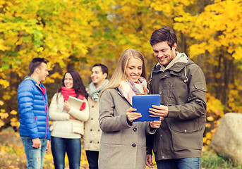 Image showing group of smiling friends with tablets in park