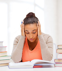 Image showing tired student with books and notes