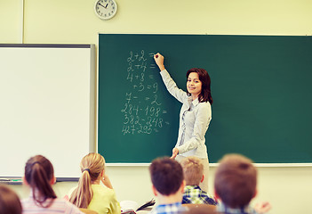 Image showing school kids and teacher writing on chalkboard