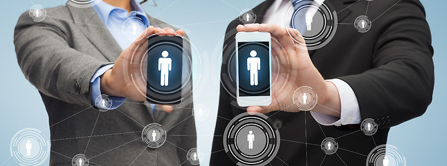 Image showing businessman and businesswoman with smartphones