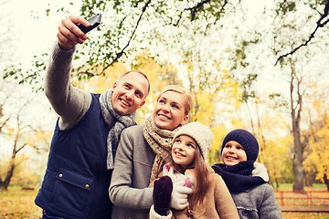 Image showing happy family with camera in autumn park