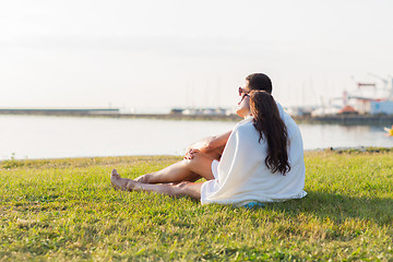 Image showing close up of couple sitting on grass at seaside