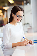 Image showing smiling woman with tablet pc at cafe