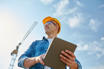 Image showing builder in hardhat with tablet pc at construction