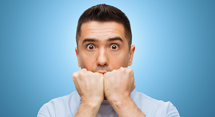 Image showing scared man face over blue background