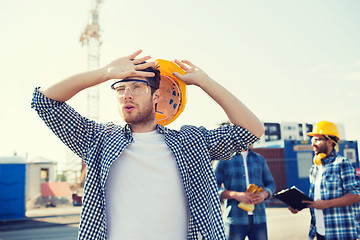 Image showing group of builders in hardhats outdoors