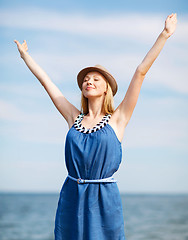 Image showing girl with hands up on the beach