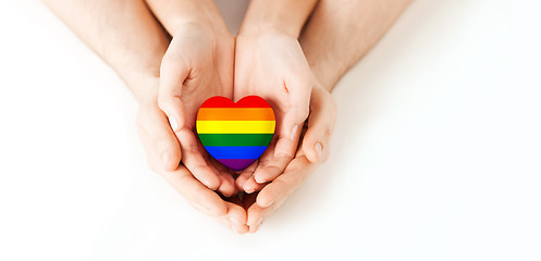 Image showing male and female hands holding rainbow heart