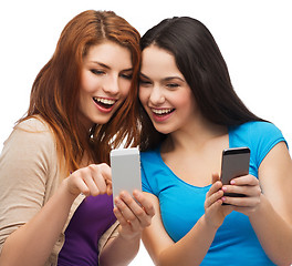 Image showing two smiling teenagers with smartphones