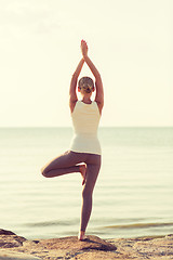 Image showing young woman making yoga exercises outdoors