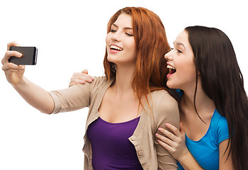 Image showing two smiling teenagers with smartphone