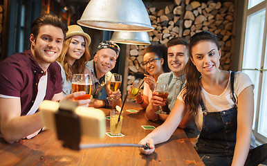 Image showing friends with smartphone on selfie stick at bar