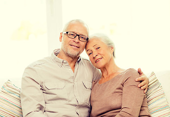 Image showing happy senior couple hugging on sofa at home