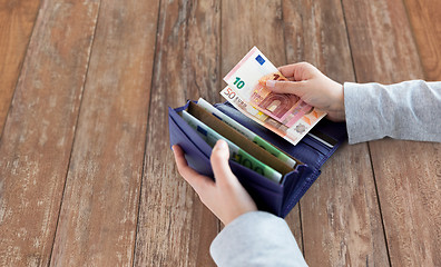 Image showing close up of woman hands with wallet and euro money